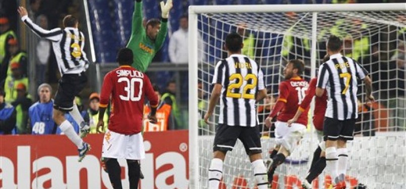 Giorgio Chiellini (kiri), pemain Juventus, mencetak gol saat laga Seri A Italia lawan AS Roma di Stadion Olimpico, Roma, Senin (12/12). 