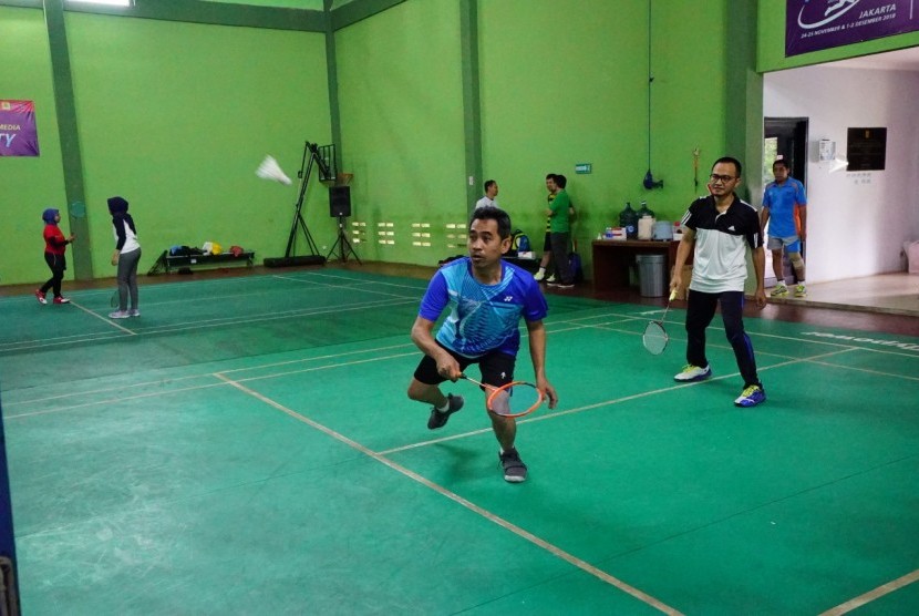 GM PLN Pusdiklat Badrul Musthafa (kanan) menyaksikan pasangannya VP Public Relations PLN Dwi Suryo Abdullah yang berjibaku mengejar bola dari lawan dalam pertandingan Badminton Electric Media Club (BMEC) di GOR Pusdiklat PLN, Rabu (1/5). 