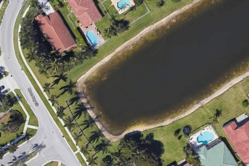 Google Earth memperlihatkan adanya sedan putih yang tercebur di tepi kolam besar di Moon Bay, Wellington, Florida, AS.