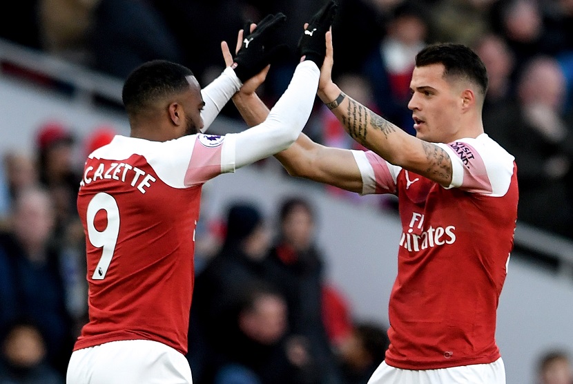 Granit Xhaka (R) merayakan golnya dengan rekan setim di Arsenal, Alexandre Lacazette (L) setelah menyarangkan gol ke gawang Manchester United di Emirates Stadium London, Ahad (10/3).