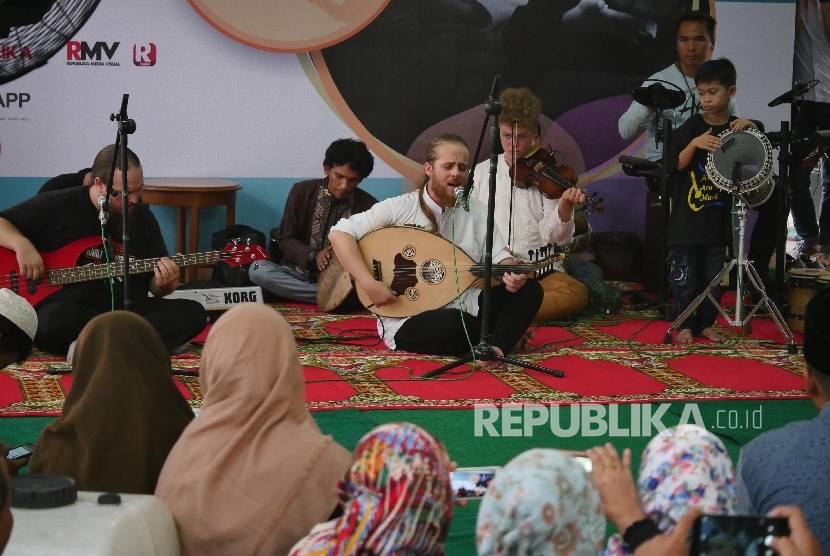 Grup musik Debu membawakan lagu karyanya dihadapan jajaran pimpinan dan karyawan Harian Republika saat acara buka puasa bersama di halaman kantor Harian Republika, Jakarta, Selasa (20/6).