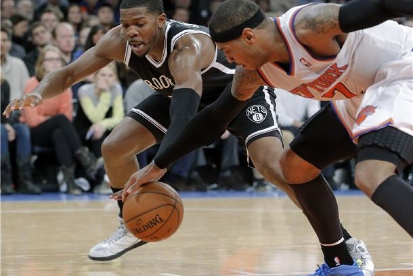 Guard Brooklyn Nets, Joe Johnson (kiri), berusaha mencuri bola dari pemain lawan dalam sebuah laga NBA. 
