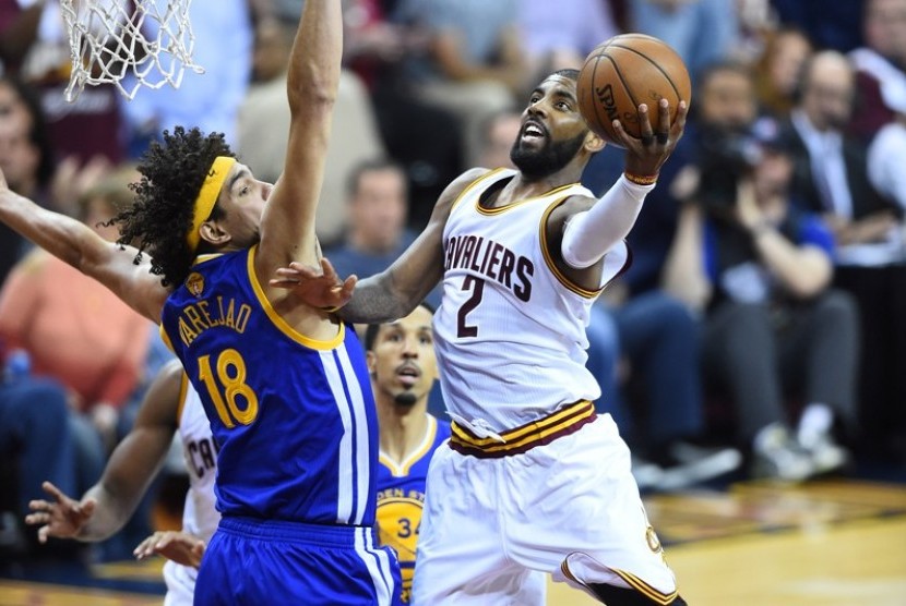 Guard Cleveland Cavaliers Kyrie Irving (kanan) melakukan lay up dijaga pemain Golden State Warriors pada gim ketiga final NBA 2016.