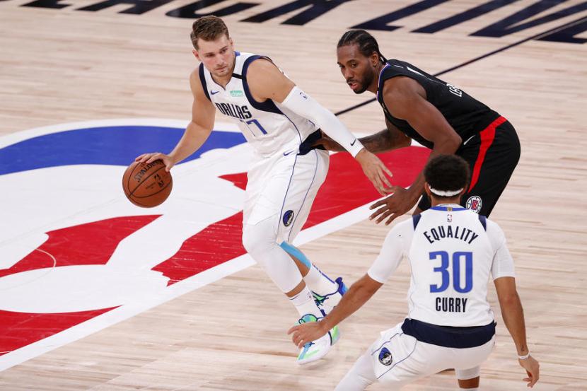 Guard Dallas Mavericks Luka Doncic (kiri) membawa bola saat dijaga forward LA Clippers Kawhi Leonard dalam laga play-off Wilayah Barat NBA.