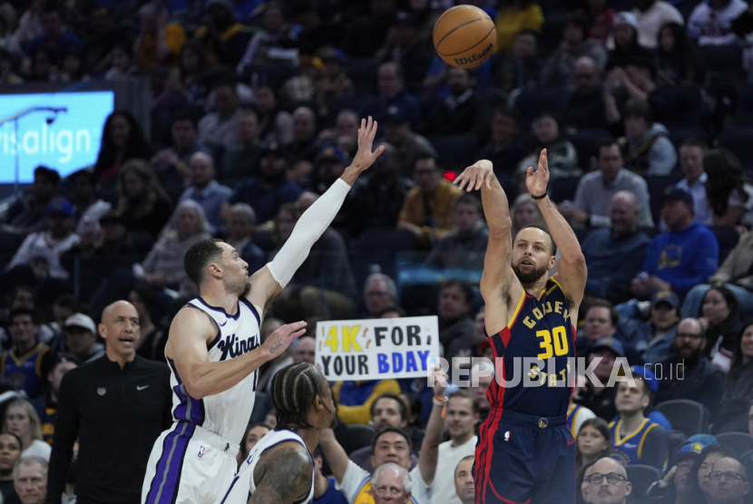 Guard Golden State Warriors Stephen Curry (30) melepaskan tembakan tripoin di samping guard Sacramento Kings Zach LaVine dalam pertandingan bola basket NBA pada Jumat, 14 Maret 2025 pagi WIB, di San Francisco