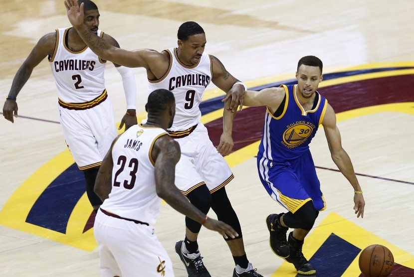 Guard Golden State Warriors, Stephen Curry (kanan) dijaga beberapa pebasket Cleveland Cavaliers pada laga final NBA 2016. Tahun ini, kedua tim kembali bertemu pada partai puncak NBA.