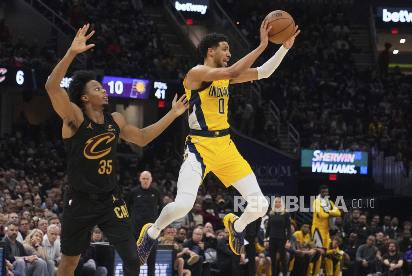 Guard Indiana Pacers Tyrese Haliburton (kanan) mengoper bola saat forward Cleveland Cavaliers Isaac Okoro bertahan dalam pertandingan gim kelima babak playoff semifinal Wilayah Timur NBA, Rabu, 13 Mei 2025 dini hari WIB, di Cleveland. 