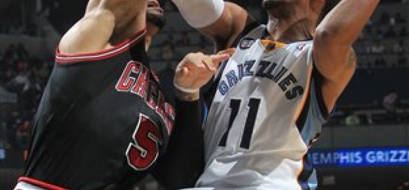 Guard Memphis Grizzlies, Mike Conley (kanan), mendapat penjagaan forward Chicago Bulls, Carlos Boozer, di pertandingan basket NBA di Memphis, Senin (16/1). 