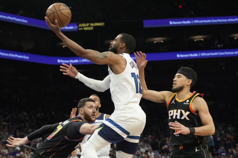 Guard Minnesota Timberwolves Mike Conley, tengah, melewati guard Phoenix Suns Devin Booker, kanan, dan center Suns Jusuf Nurkic, kiri, pada paruh pertama Game 4 seri playoff putaran pertama bola basket NBA, Senin, 29 April 2024 WIB, di Phoenix. 