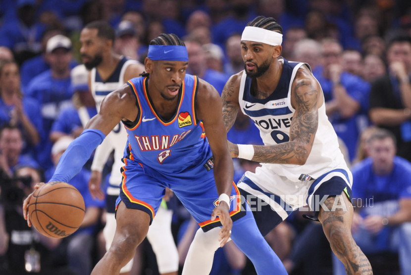 Guard Oklahoma City Thunder Shai Gilgeous-Alexander (kiri) dijaga guard Minnesota Timberwolves Nickeil Alexander-Walker dalam pertandingan gim kedua playoff final Wilayah Barat NBA, Jumat, 23 Mei 2025 pagi WIB, di Oklahoma City.