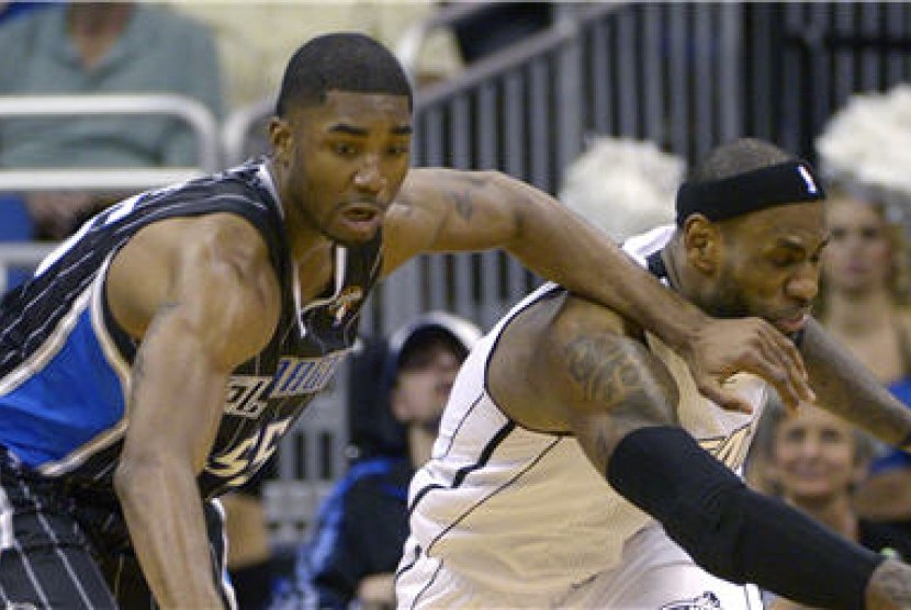 Guard Orlando Magic, E'Twaun Moore (kiri), berebut bola dengan forward Miami Heat, LeBron James, di laga NBA di Orlando, Florida, Senin (25/3). 