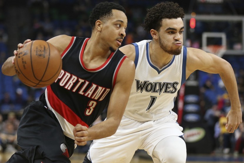 Guard Portland Trail Blazers, CJ McCollum (kiri) ditempel oleh guard Minnesota Timberwolves, Tyus Jones pada laga lanjutan kompetisi NBA, di Minneapolis, Senin (3/4).