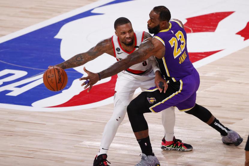 Guard Portland Trail Blazers Damian Lillard (membawa bola) dijaga bintang Los Angeles Lakers LeBron James..