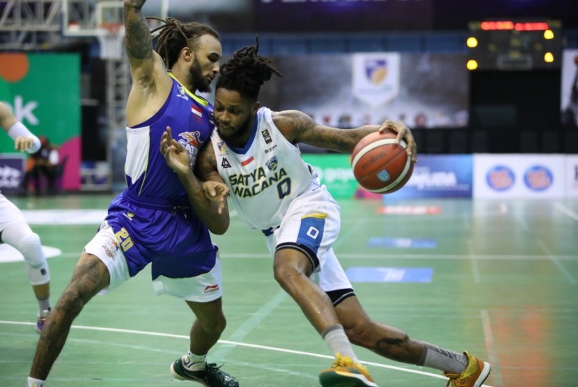 Guard Satria Muda Pertamina Gary Jacobs menjaga pemain Satya Wacana Salatiga Leshirom Montrel Williams dalam laga Seri IV IBL Pertamax 2020 di Yogyakarta, Jumat (7/2).