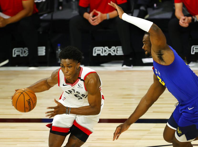 Guard Toronto Raptors Stanley Johnson membawa bola saat menghadapi Denver Nuggets dalam pertandingan NBA.