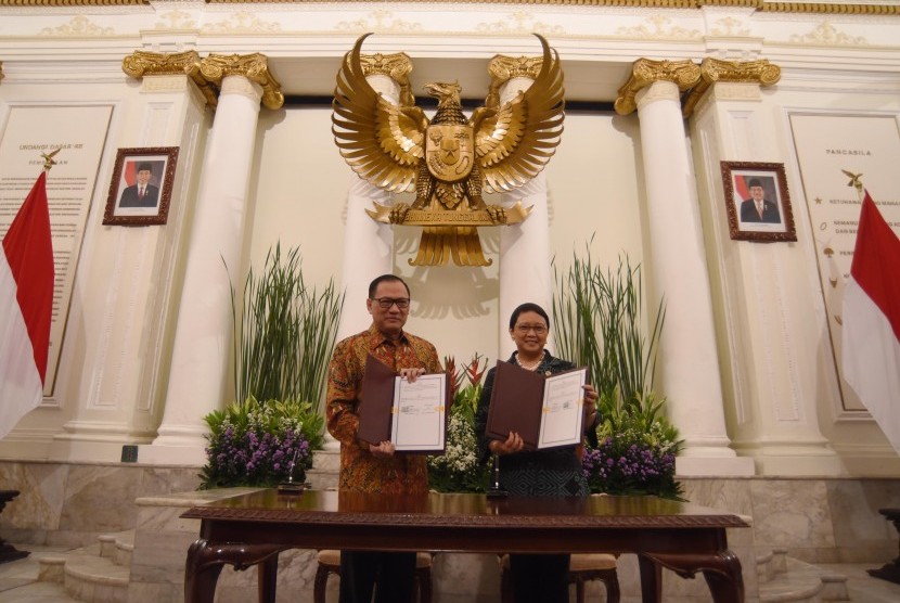 Gubernur Bank Indonesia Agus Martowardojo (kiri) bersama Menteri Luar Negeri Retno LP Marsudi (kanan) menunjukkan lembar nota kesepahaman seusai penandatanganan di Jakarta, Jumat (3/3). 