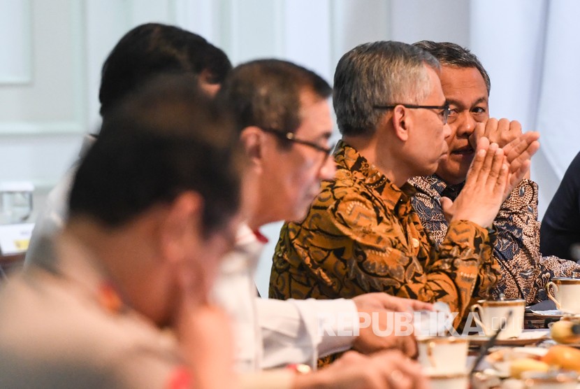 Gubernur Bank Indonesia (BI) Perry Warjiyo (kanan) berbincang dengan Ketua Dewan Komisioner Otoritas Jasa Keuangan (OJK) Wimboh Santoso (kedua kanan) sebelum mengikuti rapat terbatas (ratas) di Kantor Presiden, Jakarta, Senin (9/3/2020).(Antara/Hafidz Mubarak A)