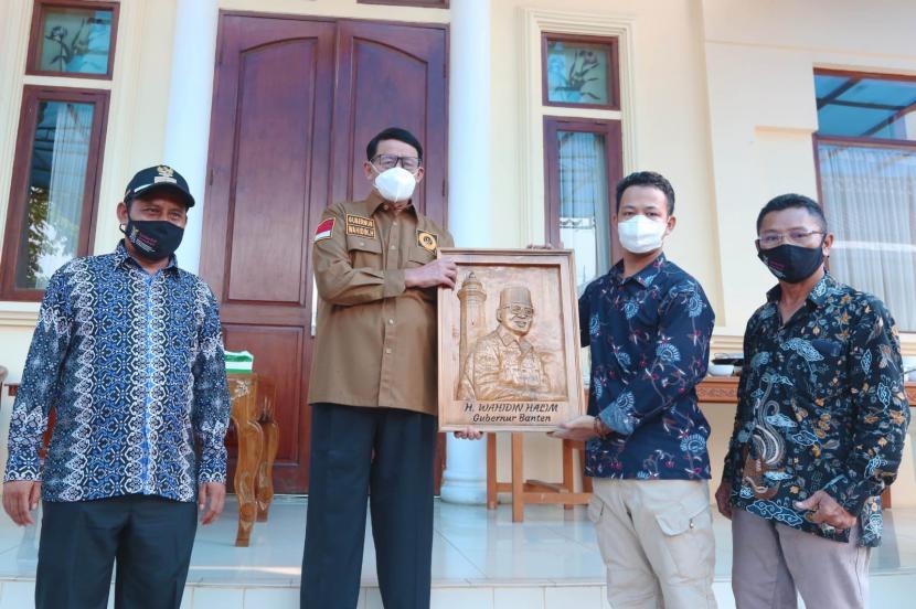 Gubernur Banten Wahidin Halim (WH) menerima ukiran wajah karya Ikbal, salah seorang seniman ukir asal Sawarna, Kabupaten Lebak di Rumah Dinas (Rumdin) Gubernur, Kota Serang pada Senin (4/10).