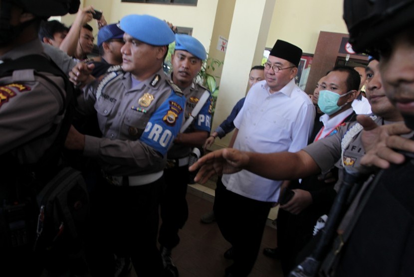 Gubernur Bengkulu Riwan Mukti (tengah) dikawal petugas kepolisian meninggalkan Reskrimsus Polda Bengkulu, Bengkulu, Selasa (20/6).