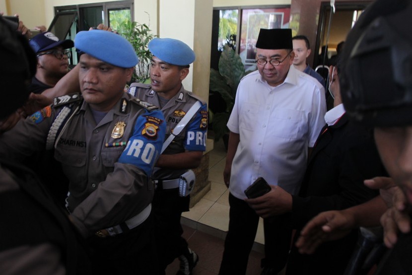 Gubernur Bengkulu Riwan Mukti (tengah) dikawal petugas kepolisian meninggalkan Reskrimsus Polda Bengkulu, Bengkulu, Selasa (20/6). 