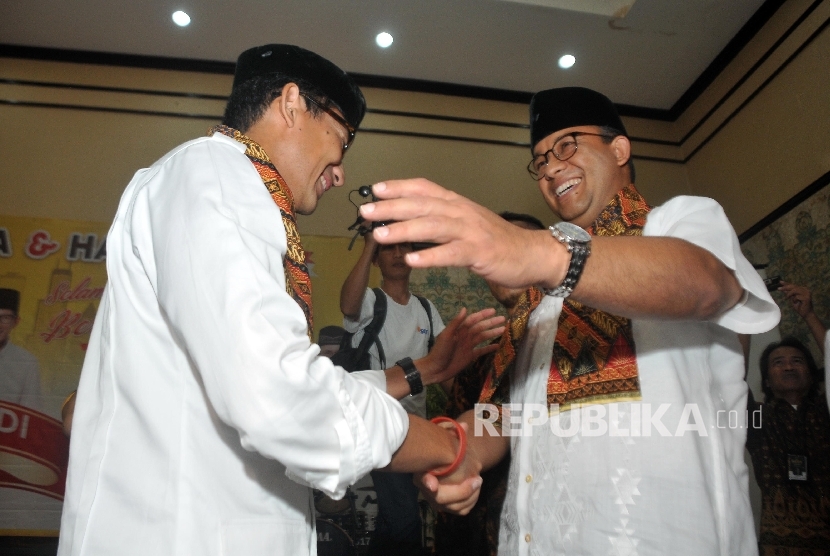 Gubernur dan Wakil Gubernur DKI Jakarta Terpilih Anies Baswedan (kanan) dan Sandiaga Uno (kiri) menghadiri acara selamatan dan doa bersama yang digelar Partai Keadilan Sejahtera (PKS) di Hotel Grand Cempaka, Jakarta, Ahad (15/10). 