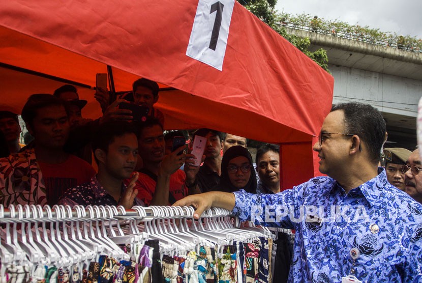 Gubernur DKI Jakarta Anies Baswedan berbincang dengan pedagang kaki lima saat meninjau Jalan Jatibaru Raya, Tanah Abang, Jakarta, Jumat (22/12).