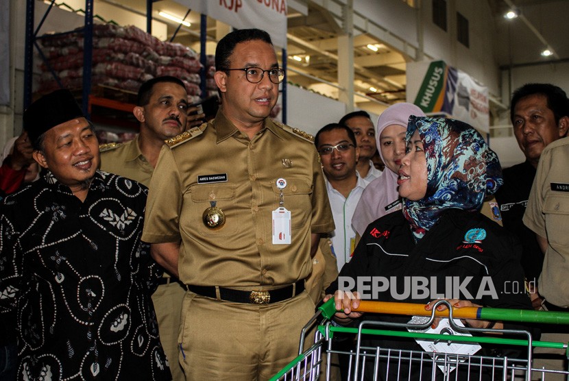 Gubernur DKI Jakarta Anies Baswedan (ketiga kiri) berbincang dengan pekerja setelah pembagian Kartu Pekerja di Jakgrosir, Pasar Induk Kramat Jati, Jakarta, Senin (31/12/2018). 