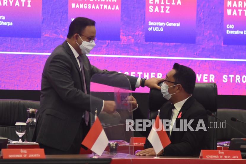 Gubernur DKI Jakarta Anies Baswedan (kiri) berbincang dengan Gubernur Jawa Barat Ridwan Kamil (kanan).