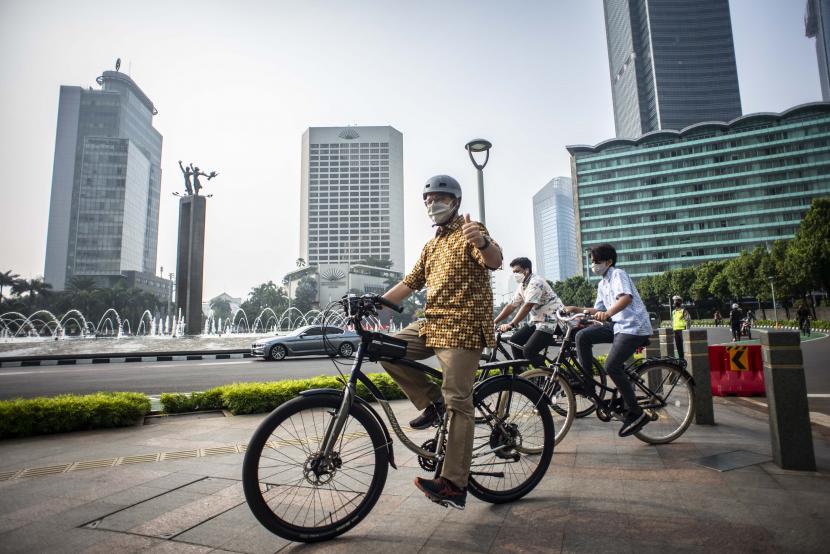 Gubernur DKI Jakarta Anies Baswedan (kiri) memakai baju batik bersepeda di kawasan Bundaran HI, Jakarta, Sabtu (2/10/2021). Kegiatan berbaju batik saat bersepeda itu sebagai bentuk perayaan memperingati Hari Batik Nasional setiap tanggal 2 Oktober.