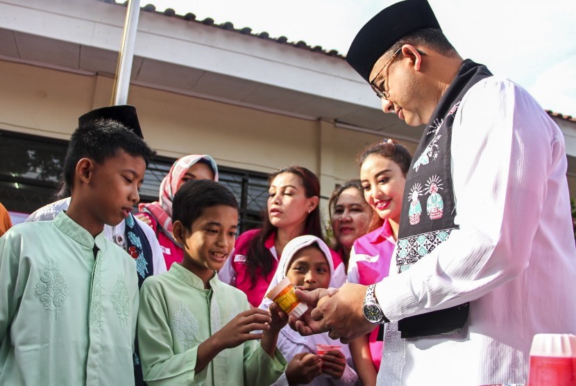 Gubernur DKI Jakarta Anies Baswedan memberikan susu dan telur rebus kepada siswa SDN 12 Pagi Cilandak saat mempromosikan program Revolusi Putih di SDN 12 Cilandak Barat, Jalan Taman Wijaya Kusuma III, Jakarta, Jumat (24/11). 