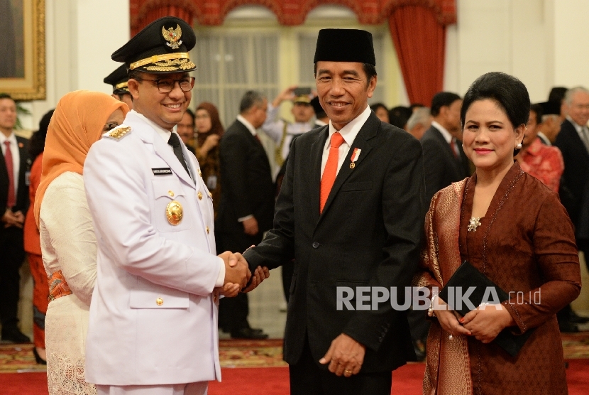 Joko Widodo (kiri) dan Juru Bicara Tim Pemenangan Pasangan Jokowi - JK, Anies Baswedan (kanan) duduk di bangku taman ketika berkunjung ke Taman Waduk Pluit di Jakarta Utara, Selasa (22/7). 