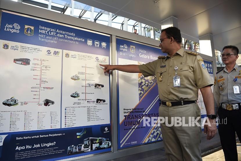 Gubernur DKI Jakarta Anies Baswedan menunjukkan media informasi moda transportasi publik yang dia luncurkan di Halte Gelora Bung Karno, Jakarta, Selasa (13/8/2019). 