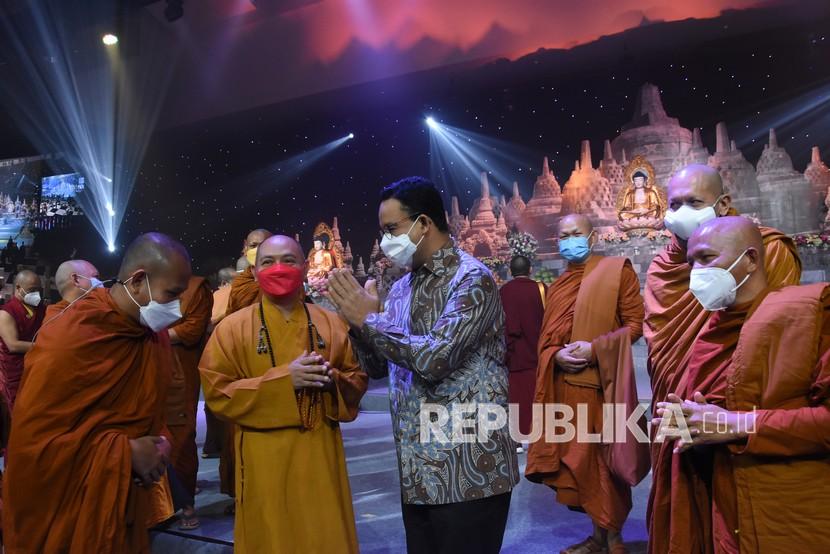 Gubernur DKI Jakarta Anies Baswedan (tengah) berdialog dengan para biksu saat menghadiri peringatan Hari Raya Tri Suci Waisak 2565 Tahun Buddhis di JIExpo Kemayoran, Jakarta, Rabu (26/5/2021). Peringatan Tri Suci Waisak yang digelar di masa pandemi tersebut menerapkan protokol kesehatan yang ketat dengan pembatasan umat Budha yang beribadah sebanyak 300 orang. 
