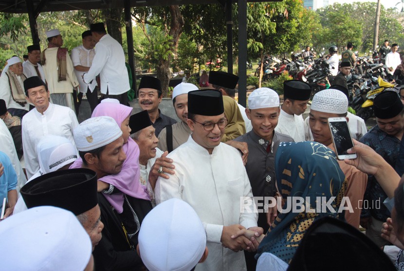 Gubernur DKI Jakarta Anies Baswedan (tengah) bersalaman dengan warga usai menghadiri kegiatan halalbihalal dan doa bersama saat perayaan Idul fitri hari kedua di Makam Wakaf Muslim, Lebak Bulus, Jakarta, Kamis (6/6/2019).