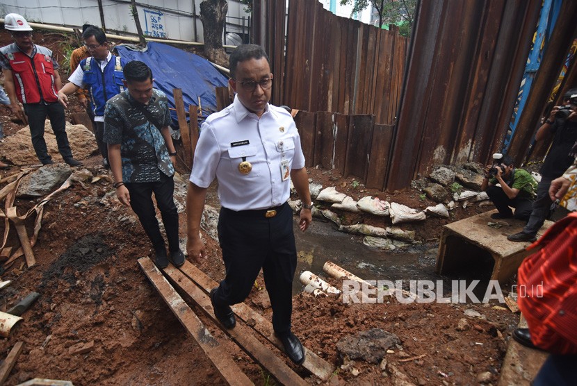 Gubernur DKI Jakarta Anies Baswedan (tengah) meninjau titik banjir yang bersebelahan dengan proyek LRT di Underpass Cawang, Jakarta, Kamis (4/4/2019). 