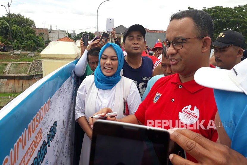 Gubernur DKI Jakarta Anies Bawedan di Perayaan Hari Guru di Jembatan Kanal Banjir Timur (KBT), RW 14 Cipinang, Jakarta Timur, Ahad (26/11).