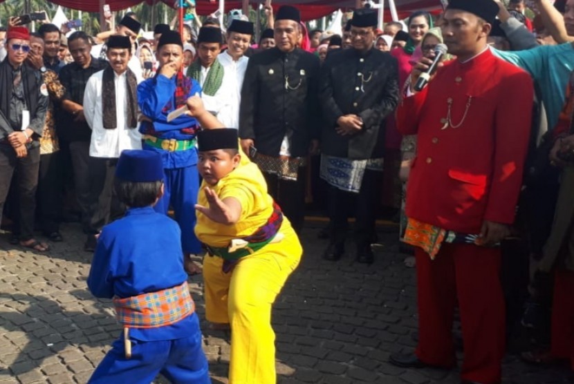 Gubernur DKI Jakarta Anies Rasyid Baswedan dan Politikus PKS Hidayat Nur Wahid disambut kesenian Palang Pintu di Lebaran Betawi 2019, Monas, Jakarta Pusat, Ahad (21/7). 