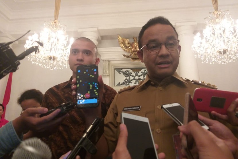 Gubernur DKI Jakarta Anies Rasyid Baswedan (kanan) dan Direktur PT Indonesia Lebih Aman Muhammad Fardhan (kiri) di Balai Kota, Jakarta Pusat, Selasa (12/3).