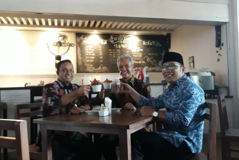 Gubernur DKI Jakarta Anies Rasyid Baswedan (kiri), Gubernur Jawa Tengah Ganjar Pranowo (tengah), dan Gubernur Jawa Barat Ridwan Kamil (kanan), minum kopi bersama di kafe JakBistro, Balai Kota DKI Jakarta, seusai menerima penghargaan dari Komisi Informasi Publik (KIP) kategori Badan Publik Pemerintah Provinsi Kualifikasi Informatif di Istana Wakil Presiden, Jalan Kebon Sirih, Jakarta Pusat, Senin (5/11).