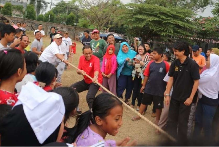 Gubernur DKI Jakarta Anies Rasyid Baswedan mengikuti perlombaan tarik tambang di lingkungan kediamannya di Jalan Lebak Bulus 1, Cilandak Barat, Jakarta Selatan, Jumat (17/8). Dia melakukan selebrasi usai menang pada permainan pertama.