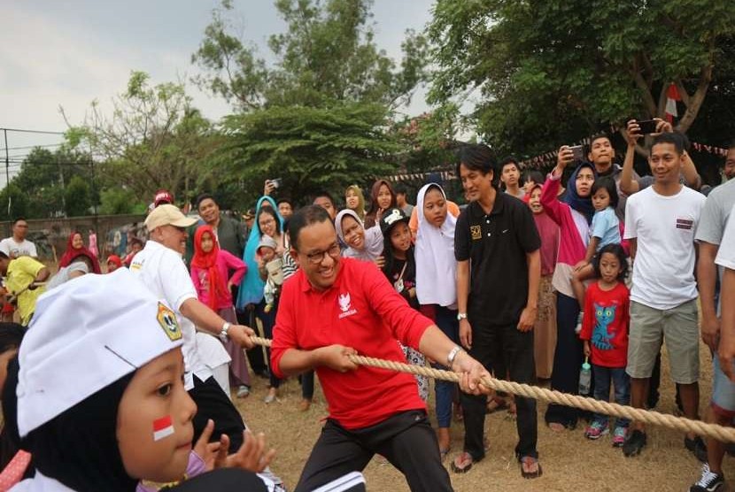 Gubernur DKI Jakarta Anies Rasyid Baswedan mengikuti perlombaan tarik tambang di lingkungan kediamannya di Jalan Lebak Bulus 1, Cilandak Barat, Jakarta Selatan, Jumat (17/8). Dia melakukan selebrasi usai menang pada permainan pertama.