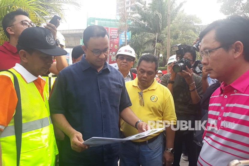 Gubernur DKI Jakarta Anies Rasyid Baswedan meninjau proyek penataan trotoar dan jalan di ruas Jalan Sudirman hingga Jalan MH Thamrin, Jakarta Pusat, Ahad (22/7).