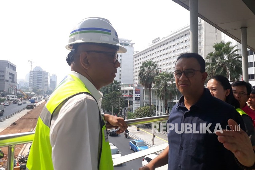 Gubernur DKI Jakarta Anies Rasyid Baswedan meninjau proyek penataan trotoar dan jalan di ruas Jalan Sudirman hingga Jalan MH Thamrin, Jakarta Pusat, Ahad (22/7).