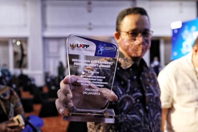 Gubernur DKI Jakarta Anies Rasyid Baswedan menunjukkan plakat penghargaan yang diterima.