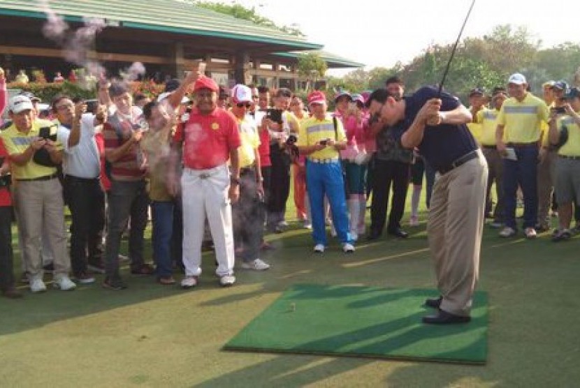 Gubernur DKI Jakarta Basuki Tjahaja Purnama alias Ahok memegang stik golf.