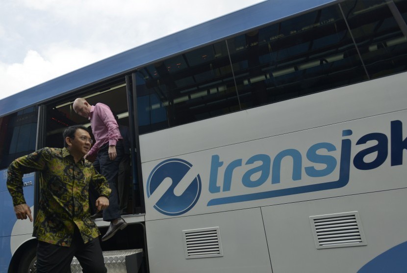 Gubernur DKI Jakarta Basuki Tjahaja Purnama (kiri) diikuti Duta Besar Australia untuk Indonesia Paul Grigson (kanan) turun dari bus Transjakarta saat meninjau kantor PT Transjakarta, Jakarta, Kamis (3/3).