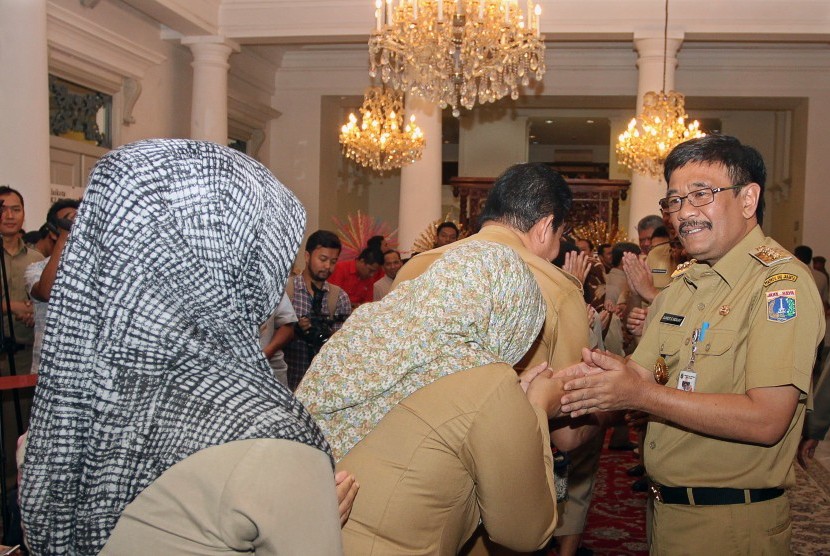 Gubernur DKI Jakarta Djarot Saiful Hidayat (kanan) bersalaman dengan Pegawai Negeri Sipil (PNS) saat halal bihalal di Balai Kota, Jakarta, Senin (3/7).