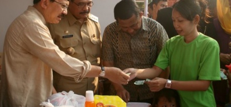 Gubernur DKI Jakarta, Fauzi Bowo (Foke) melayani penukaran kupon untuk sembako pada pembukaan Pasar Murah di Jakarta.