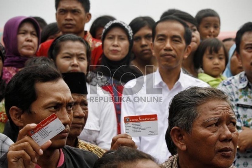   Gubernur DKI Jakarta, Joko Widodo berfoto bersama dengan warga usai membagikan Kartu Jakarta Sehat di kelurahan Marunda, Jakarta Utara, Senin (12/11).   (Adhi Wicaksono)