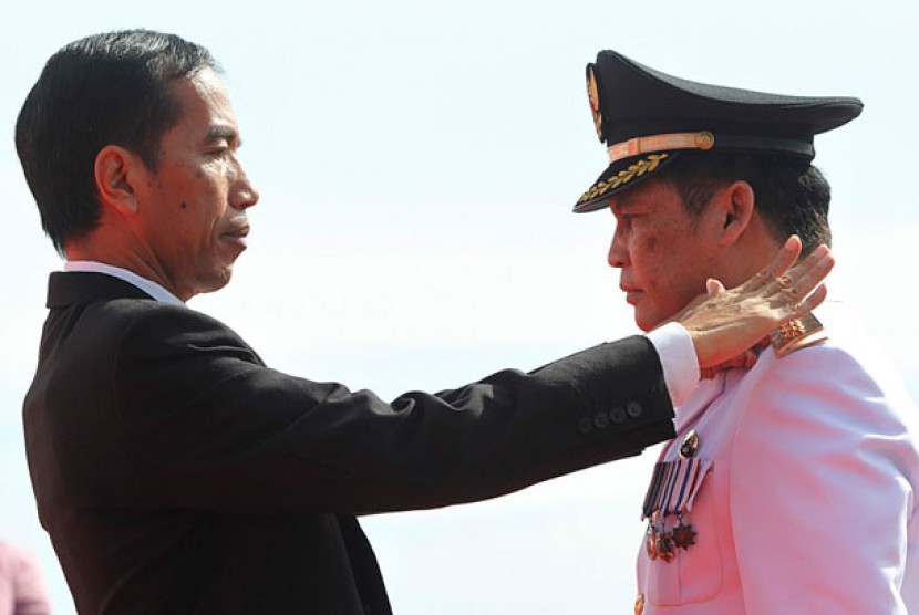 Gubernur DKI Jakarta Joko Widodo (kiri) menyematkan tanda pangkat dan jabatan kepada Bupati Kepulauan Seribu Asep Syarifudin (kanan) di Pantai Pasir Perawan, Pulau Pari, Kepulauan Seribu, Rabu (5/6). 